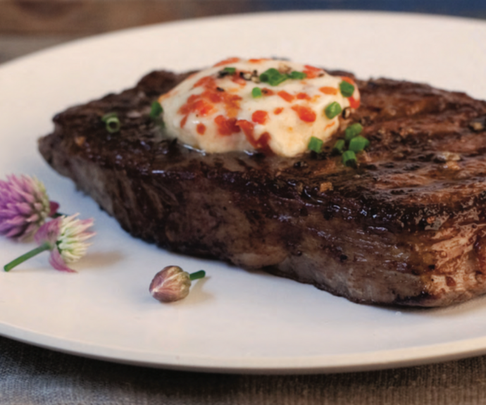 Chile-rubbed rib eye steaks with roasted red pepper butter